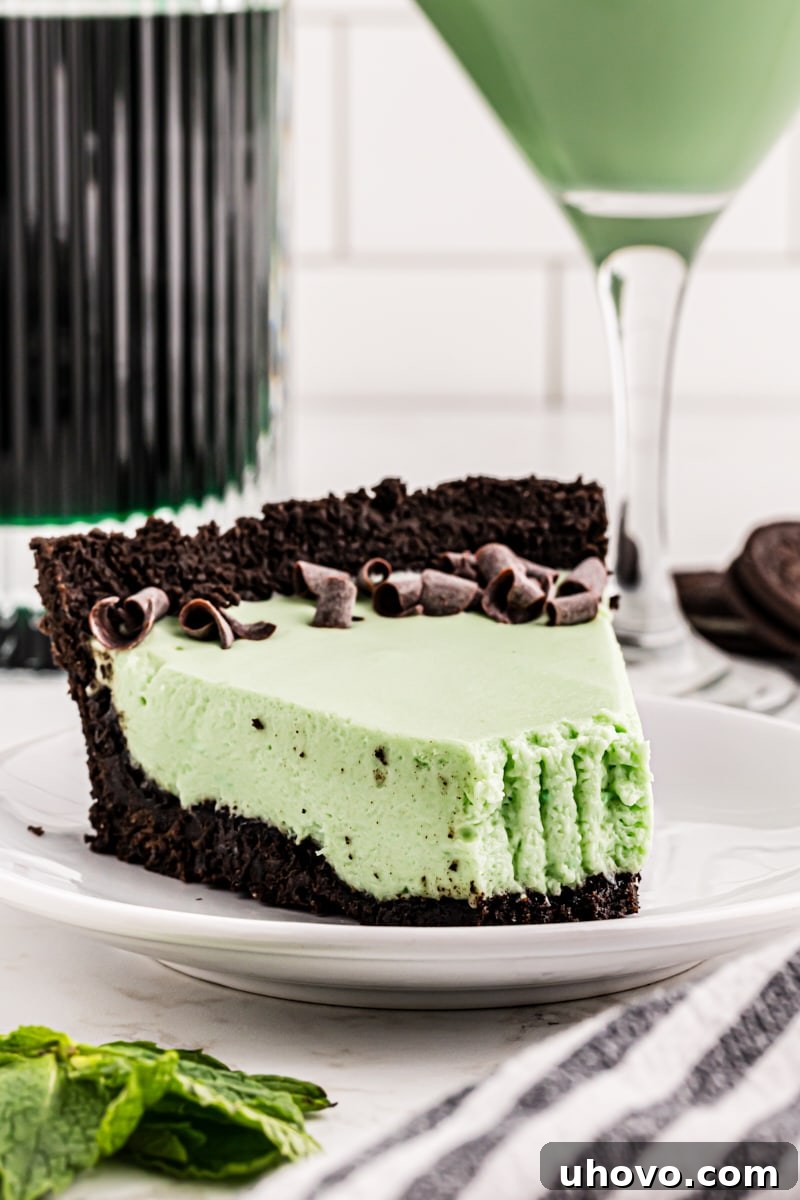 A tempting slice of Grasshopper Pie with a small bite missing, perfectly showcasing its rich chocolate crust and smooth, green mint filling.