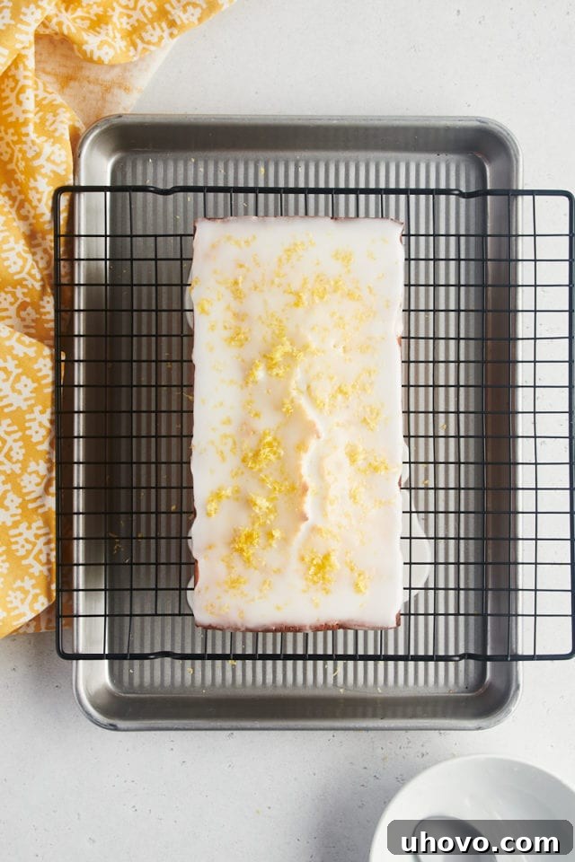 Overhead view of lemon loaf cake after adding glaze and zest