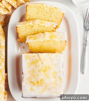 Overhead view of half sliced lemon loaf cake on platter