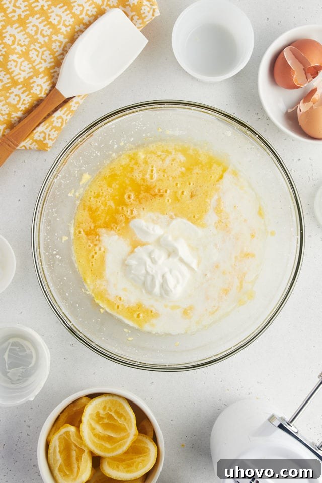 Overhead view of sour cream and milk added to bowl of wet ingredients