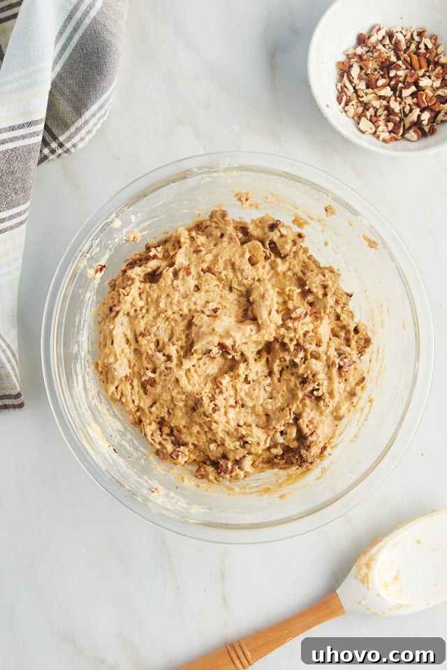 Overhead view of cinnamon pecan muffin batter in glass bowl
