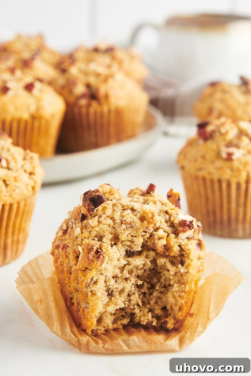 Cinnamon pecan muffin with bite taken out to show tender crumb