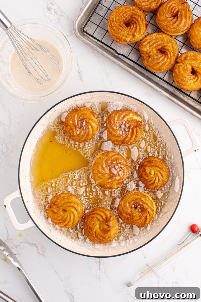 Overhead view of French crullers frying in oil