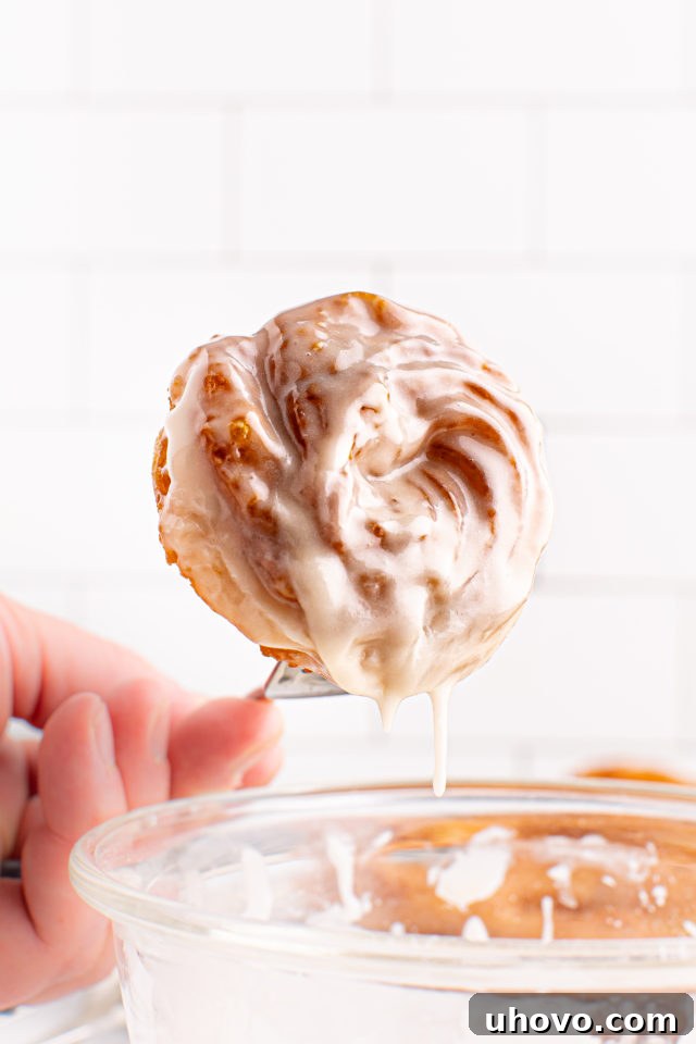 Dipping cruller into glaze