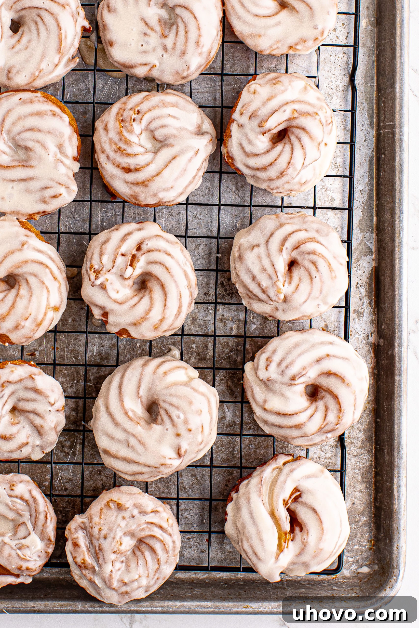 Overhead view of French crullers on wire rack set on sheet pan