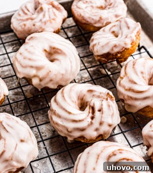Glazed crullers on wire rack set on sheet pan