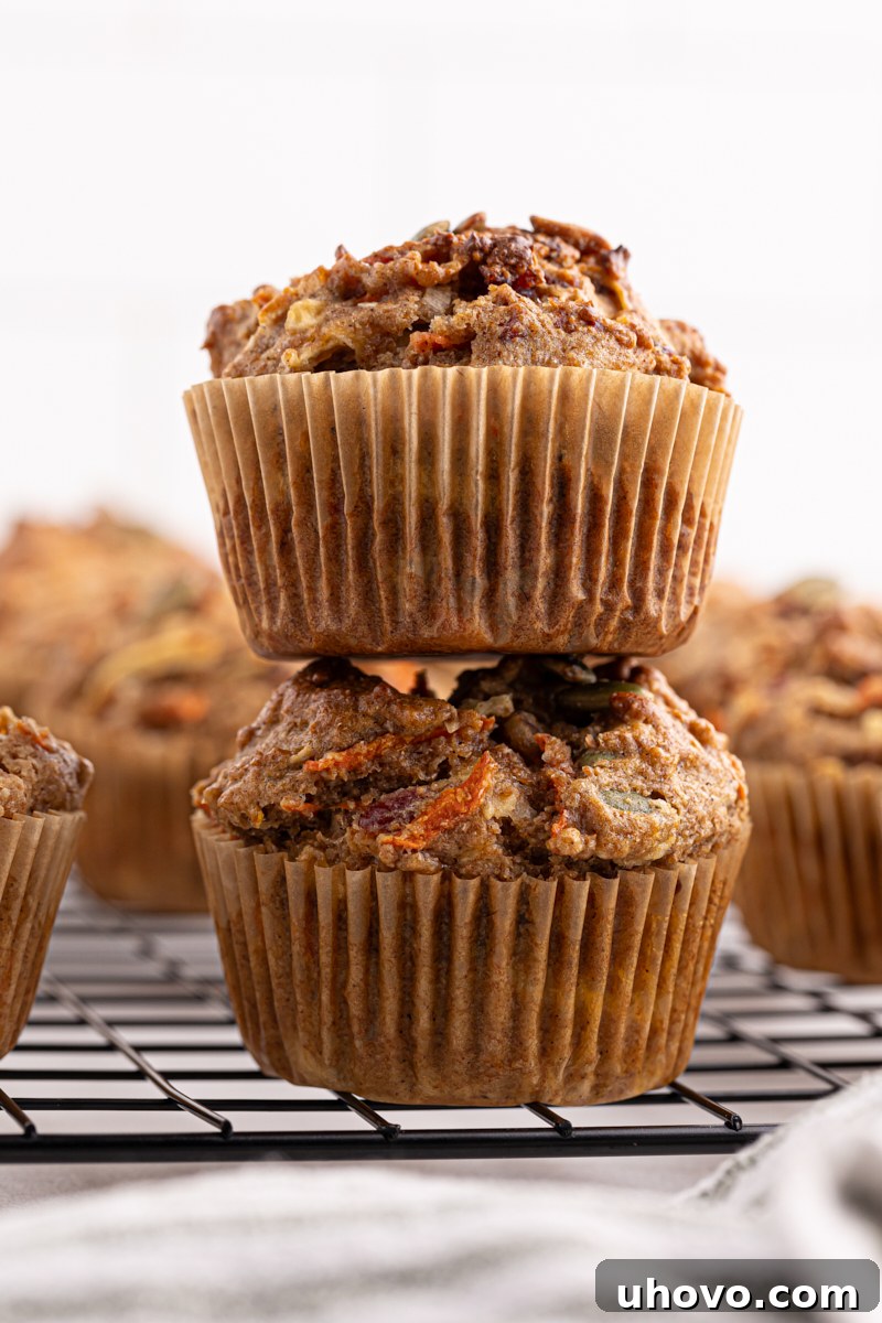 Two freshly baked Morning Glory Muffins stacked artfully on top of each other, emphasizing their height and fluffy texture.
