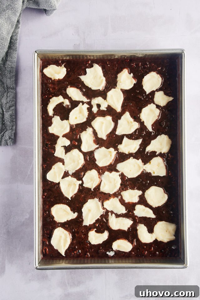 Overhead view of cream cheese added to earthquake cake batter