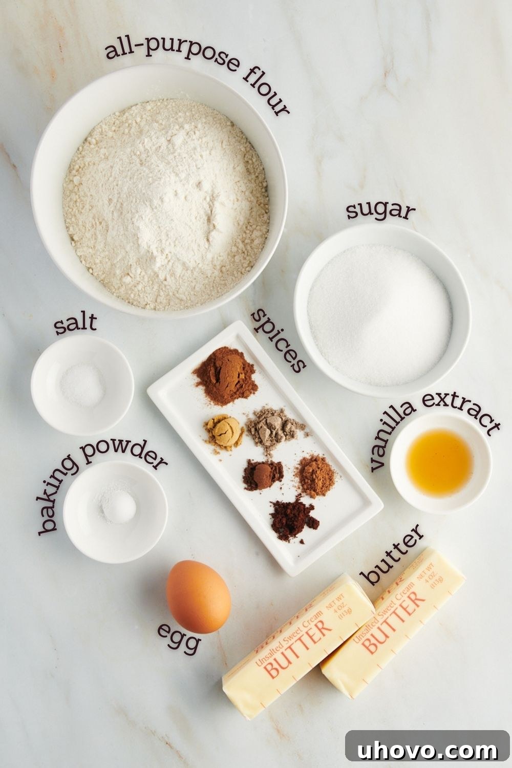 An overhead view showcasing all the essential ingredients for making chai sugar cookies, neatly arranged on a countertop with clear labels.