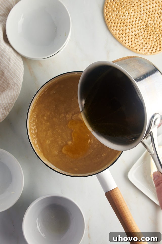 overhead view of brown butter added to flour mixture for financiers