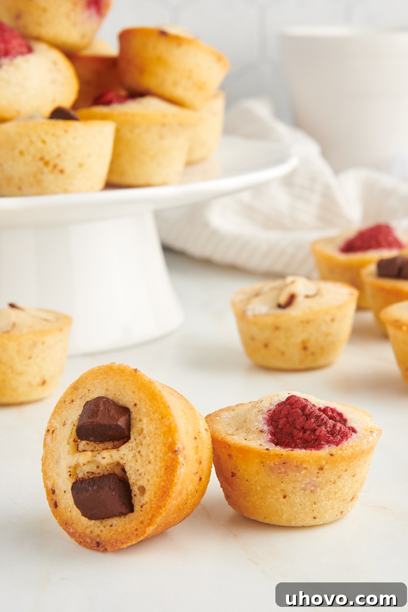 two financiers on a marble surface with more cakes in the background