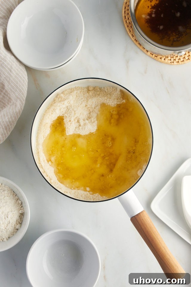 overhead view of sugar, almond flour, and egg whites in a saucepan