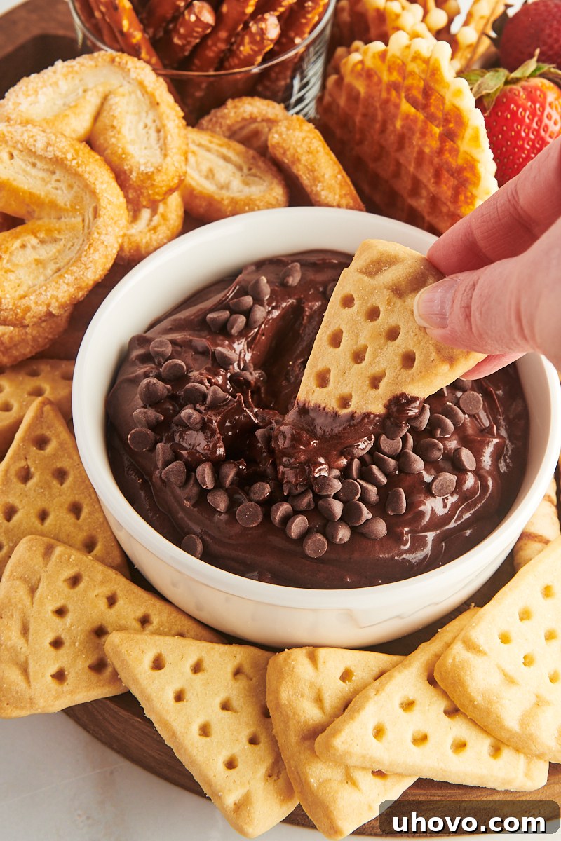 A tempting image of a shortbread cookie being perfectly dipped into a bowl of rich, creamy brownie batter dip.