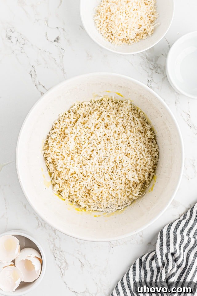 Overhead view of sweetened shredded coconut and flour being added to the whisked egg mixture for the topping