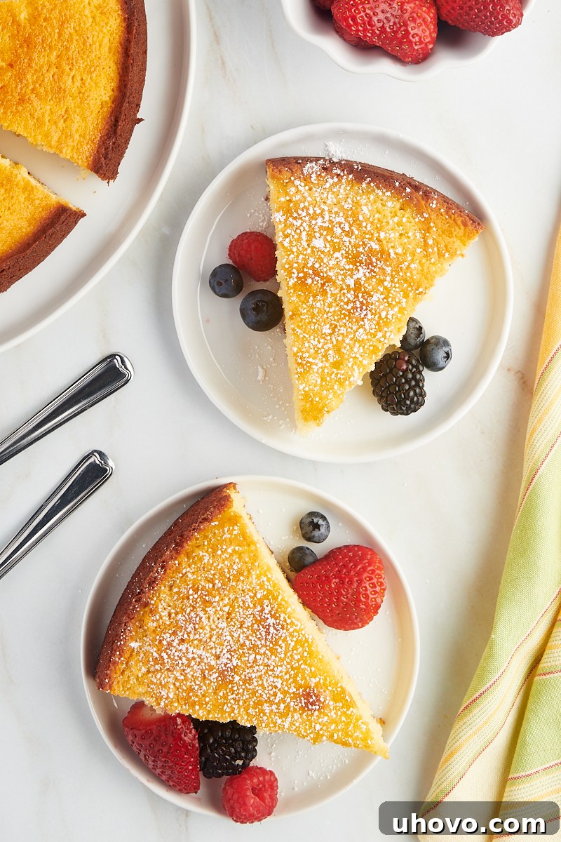 overhead view of two inviting slices of lemon ricotta cake, each garnished with fresh berries, presented on elegant white plates