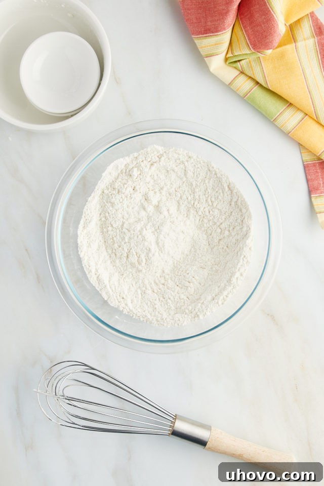 overhead view of combined dry ingredients for lemon ricotta cake, including flour, baking powder, and salt, in a mixing bowl