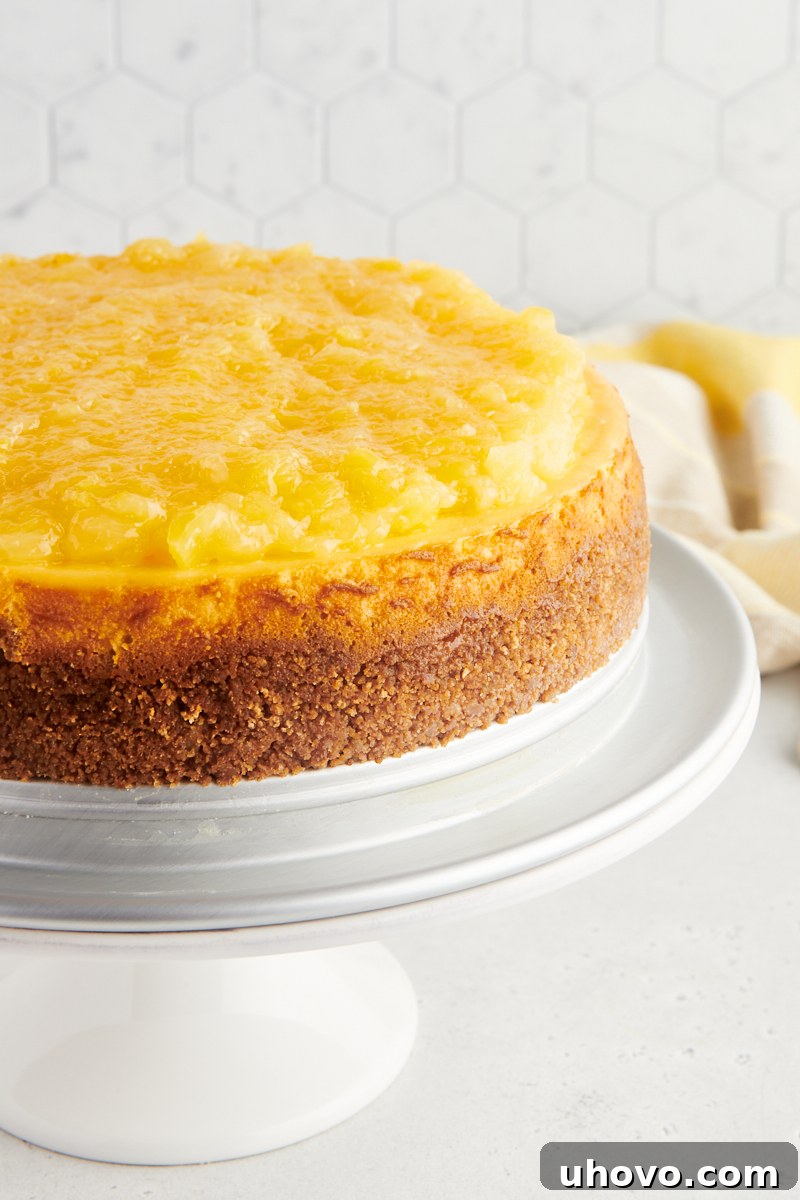 A stunning whole pineapple cheesecake, adorned with its golden topping, resting elegantly on a cake stand, ready to be admired and enjoyed at a special occasion.