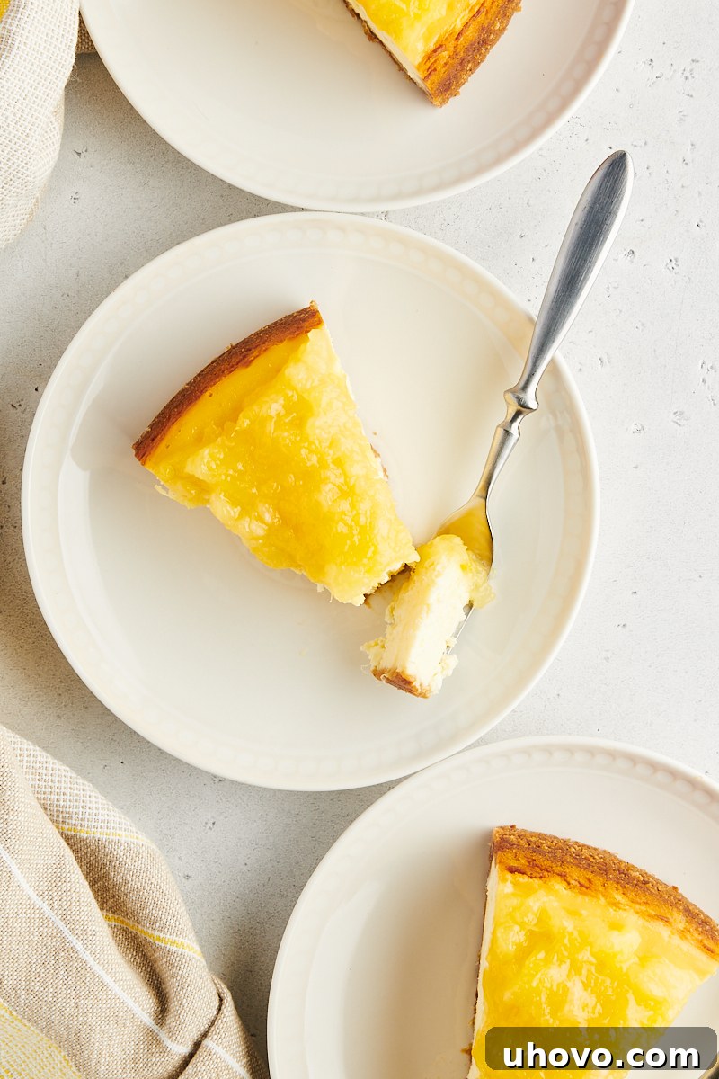 Two perfectly portioned slices of pineapple cheesecake arranged on elegant white plates, ready to be savored, with the creamy filling and bright topping prominently displayed.