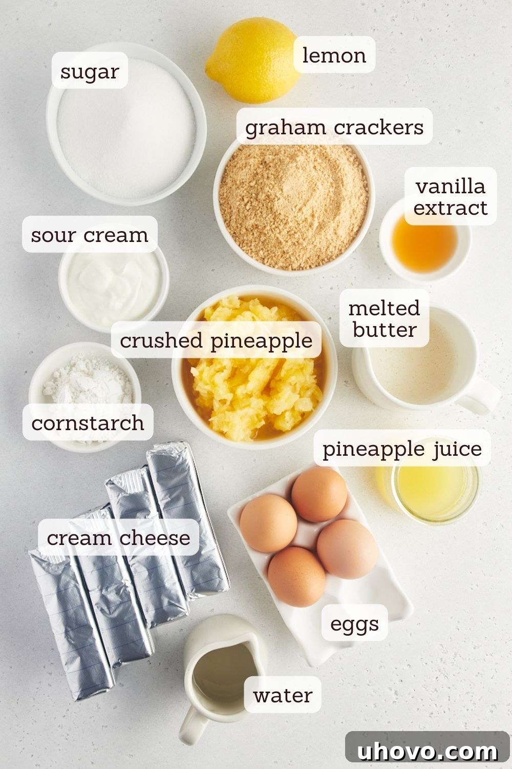A vibrant overhead shot of all the key ingredients for a pineapple cheesecake, neatly arranged on a counter with illustrative labels, from graham crackers to fresh pineapple, highlighting the quality and freshness required for this delightful tropical dessert.