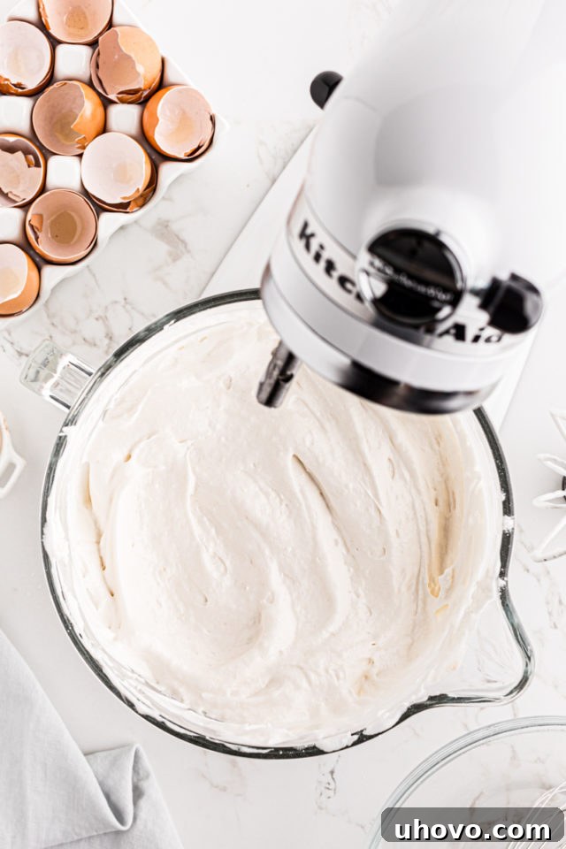 Angel Food Cake batter in a stand mixer bowl, showing its light and fluffy consistency before being transferred to the pan.