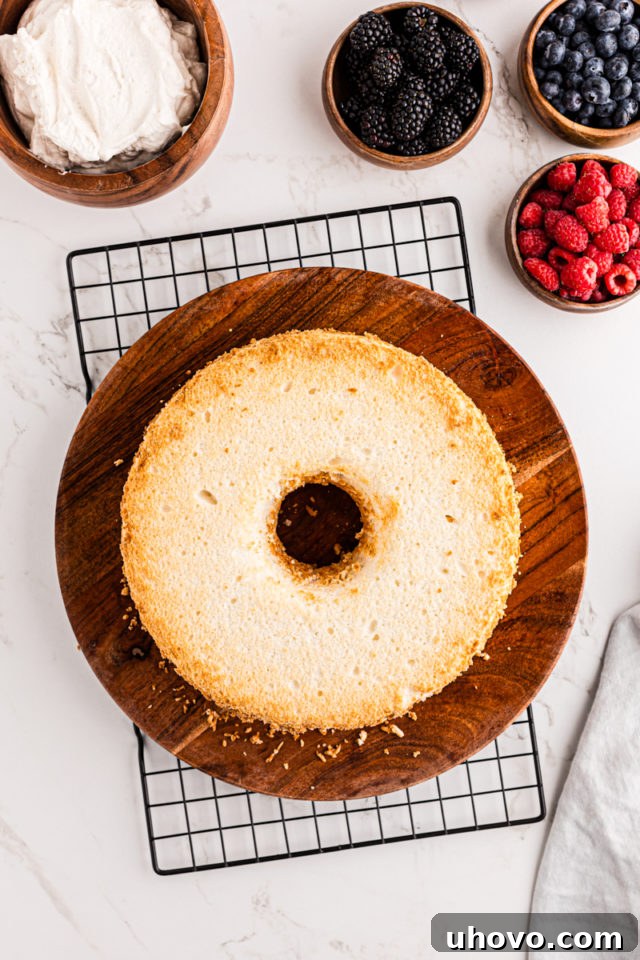 A perfectly cooled Angel Food Cake resting on a wooden serving tray, recently removed from its pan.