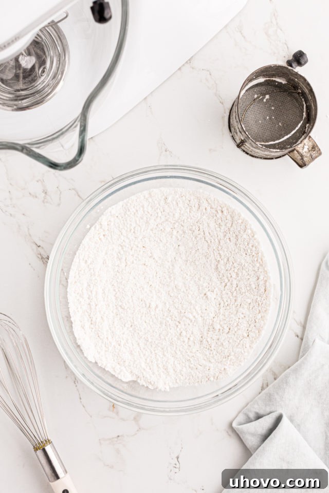 A bowl containing sifted cake flour and superfine sugar, ready for mixing, illustrating the importance of proper dry ingredient preparation.