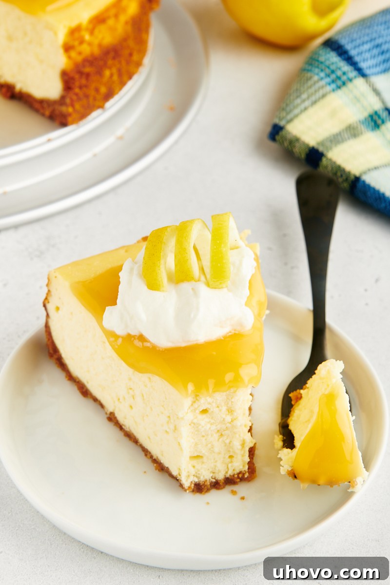 A delectable slice of lemon cheesecake on a white plate, with a fork holding a bite-sized piece, showcasing its creamy texture.