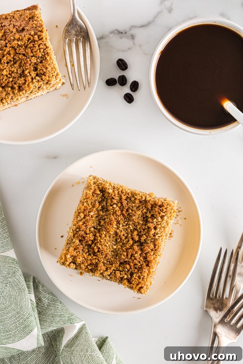 Overhead view of several slices of sour cream coffee cake served on individual plates, each accompanied by a cozy cup of coffee, inviting immediate enjoyment.