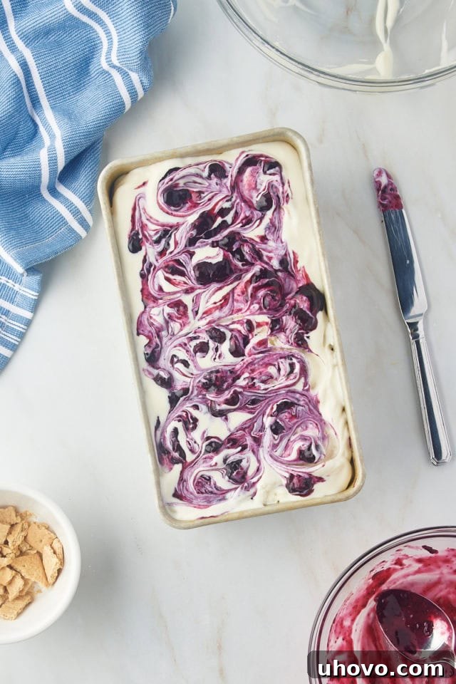 The fully layered and assembled blueberry cheesecake ice cream in a metal loaf pan, showcasing distinct swirls before freezing.
