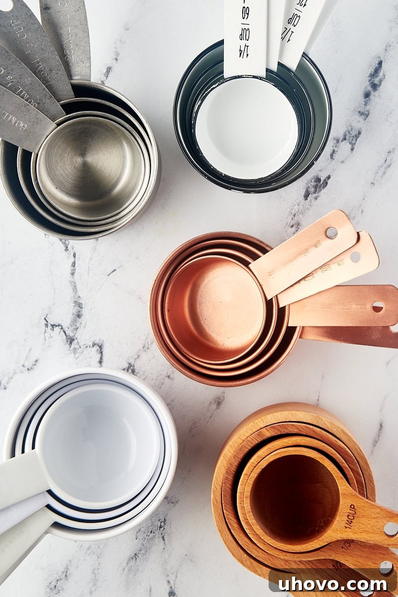 overhead view of various dry measuring cups arranged neatly on a marble surface