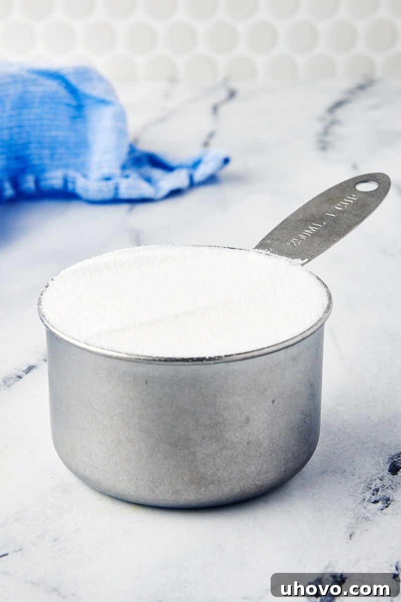 granulated sugar measured precisely in a dry measuring cup with a leveled top