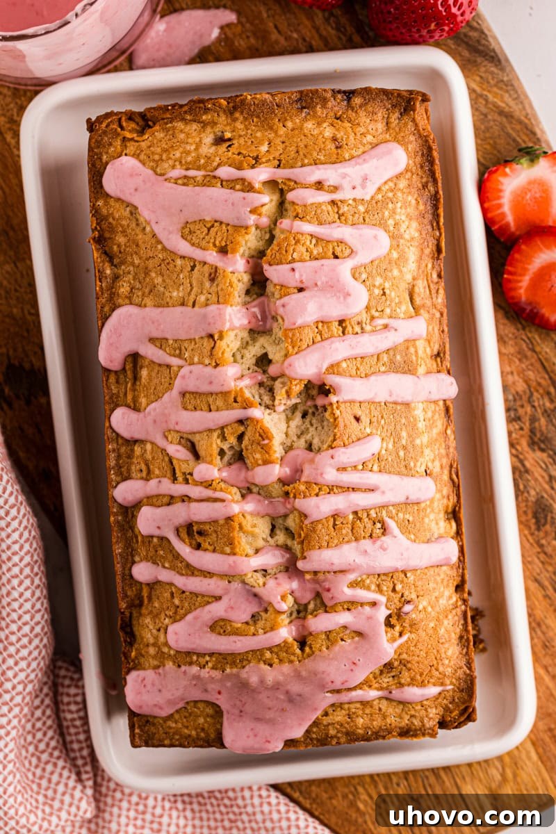An inviting overhead view of a whole strawberry pound cake, beautifully drizzled with a rich strawberry glaze, ready to be enjoyed.