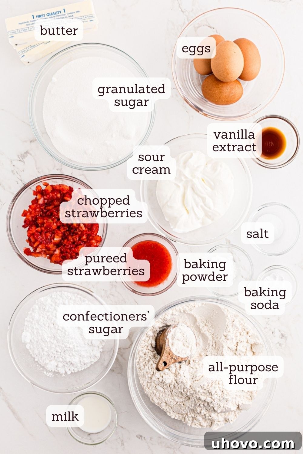 An overhead shot showcasing the fresh ingredients required for baking the strawberry pound cake, neatly arranged on a rustic surface.