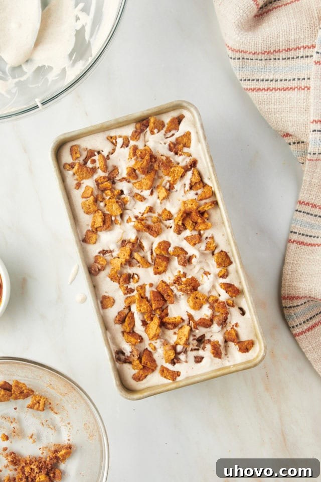 Overhead view of the fully layered churro ice cream in a loaf pan before freezing, showing the swirls