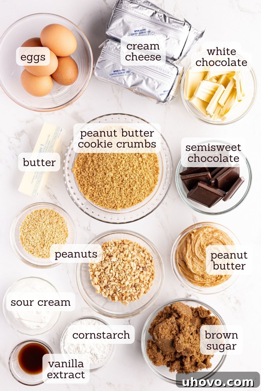 An overhead view displaying all the fresh, high-quality ingredients laid out for making the chocolate peanut butter cheesecake.