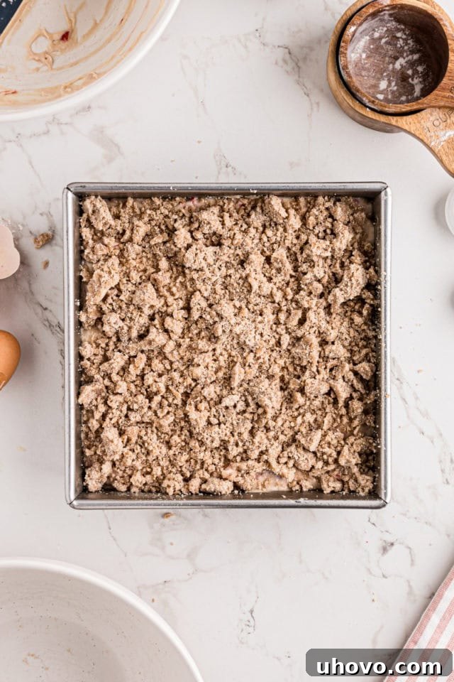 overhead view of strawberry coffee cake topped with crumb topping ready to go into the oven