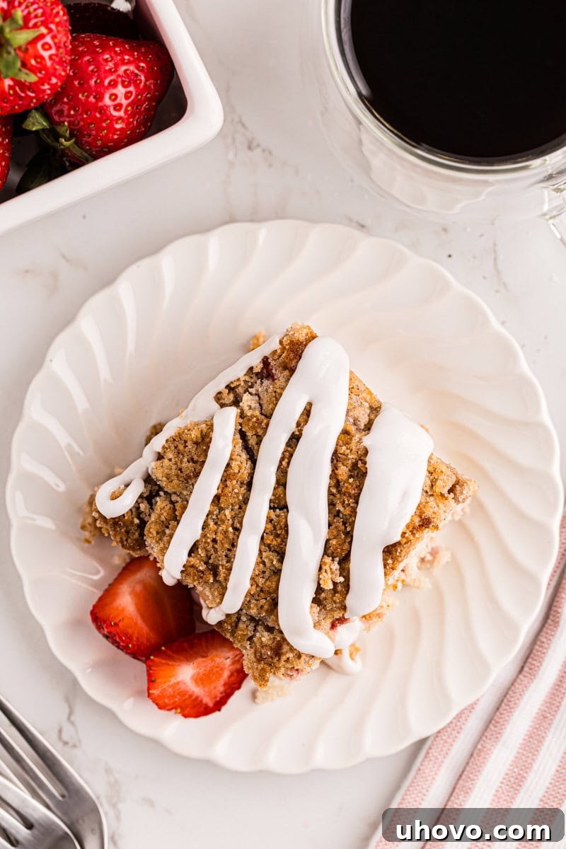 overhead view of a slice of strawberry coffee cake topped with a simple glaze