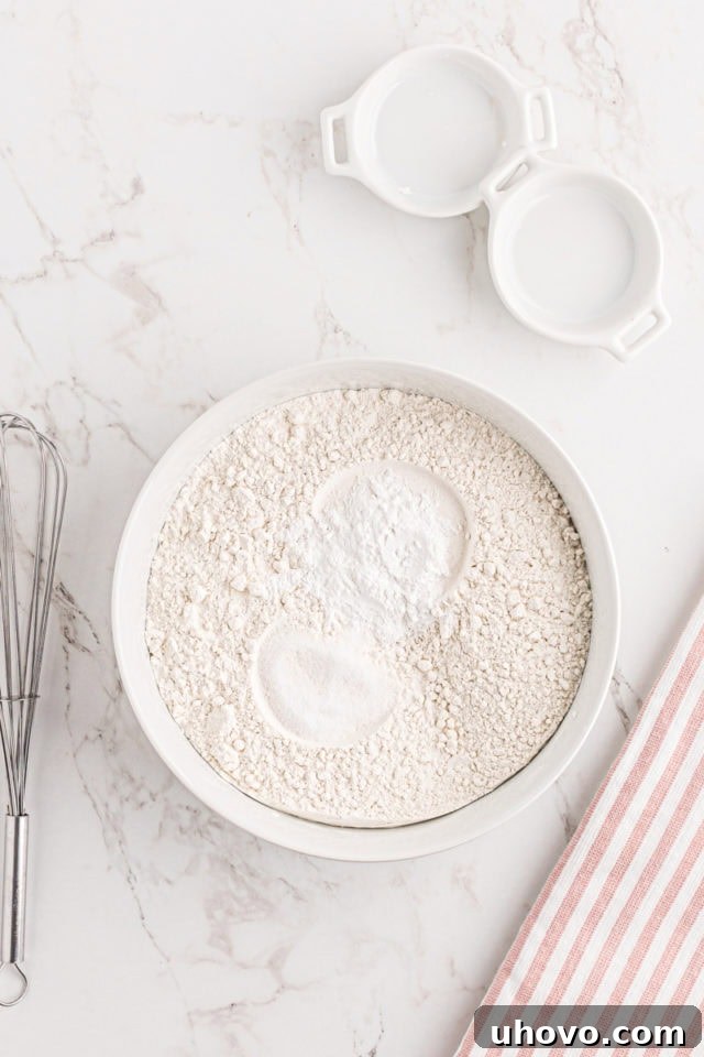 overhead view of flour, baking powder, and salt in a white mixing bowl