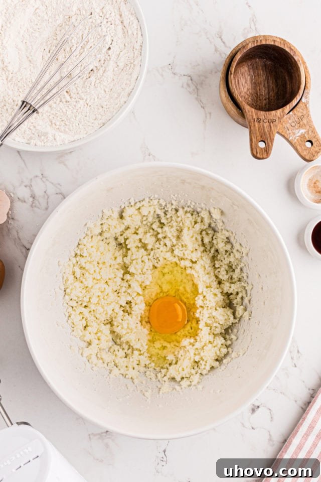 overhead view of egg added to creamed butter and sugar