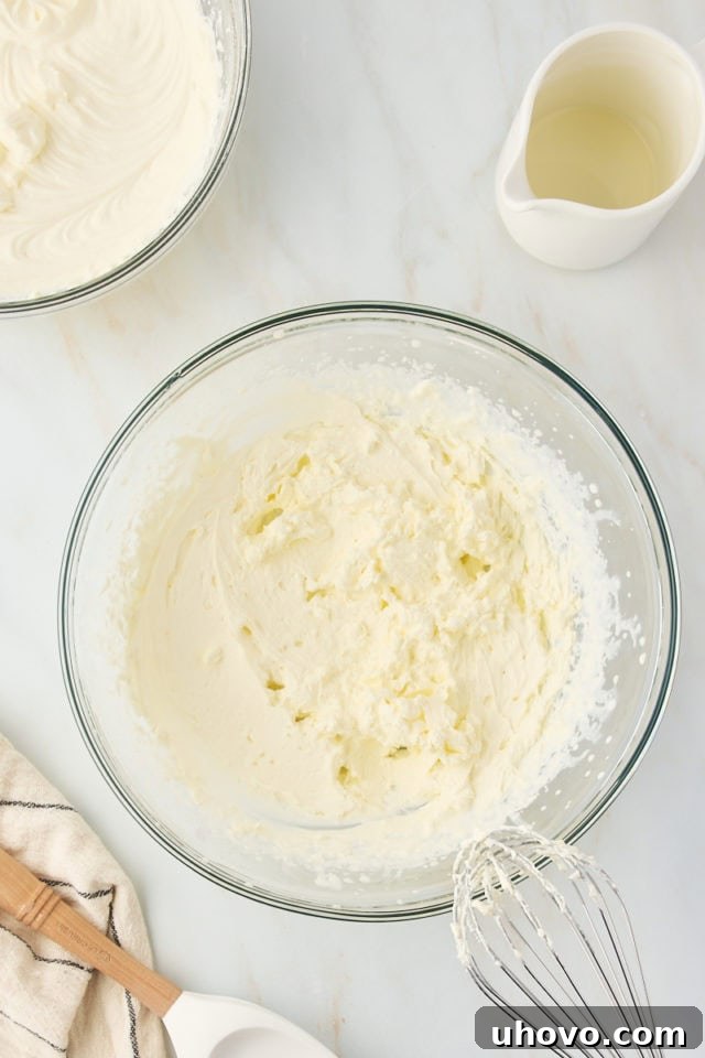 overhead view of whipped cream in a glass mixing bowl