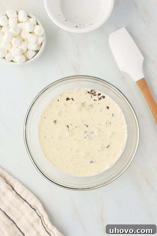 overhead view of chocolate and heated cream in a glass bowl