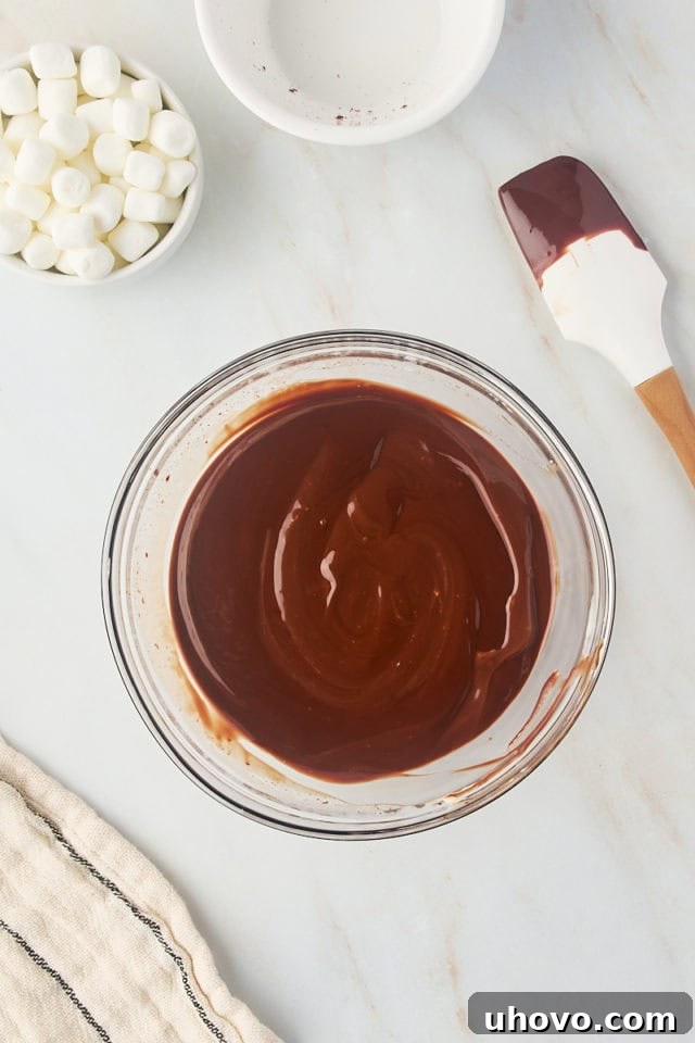 overhead view of chocolate ganache in a glass mixing bowl