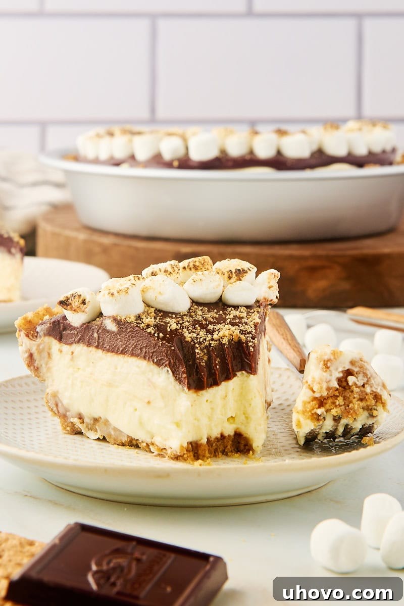 a slice of s'mores pie on a plate with a bite on a fork