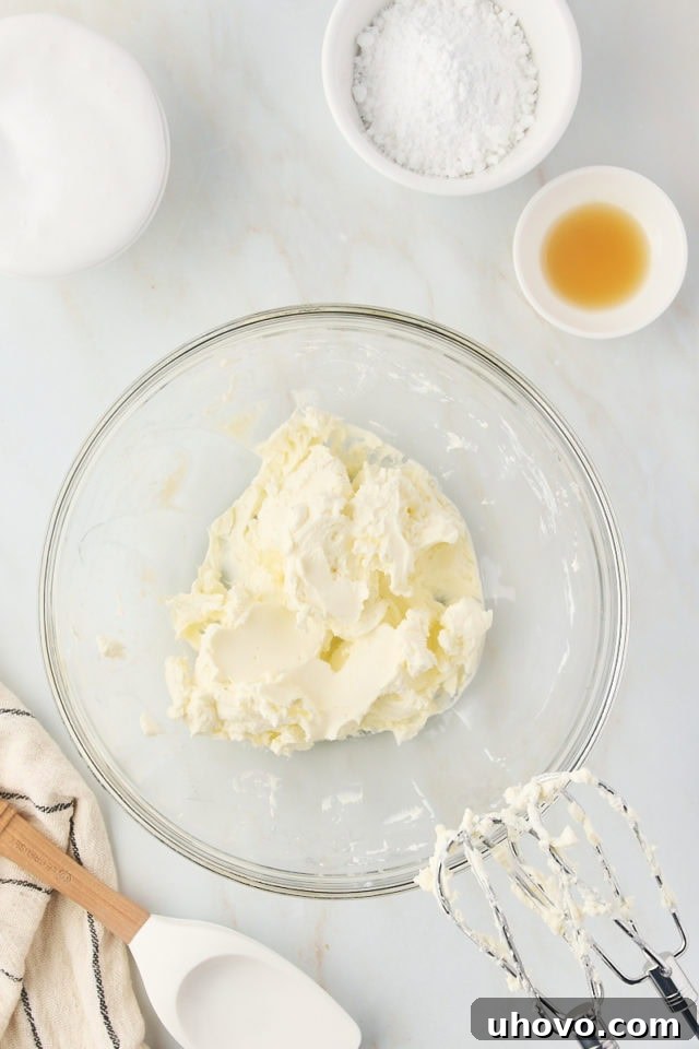 overhead view of beaten cream cheese in a glass mixing bowl