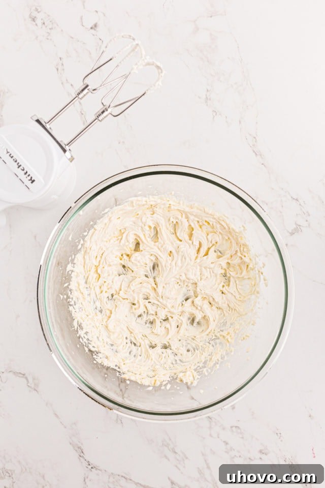 overhead view of mixed cream cheese frosting in a glass mixing bowl