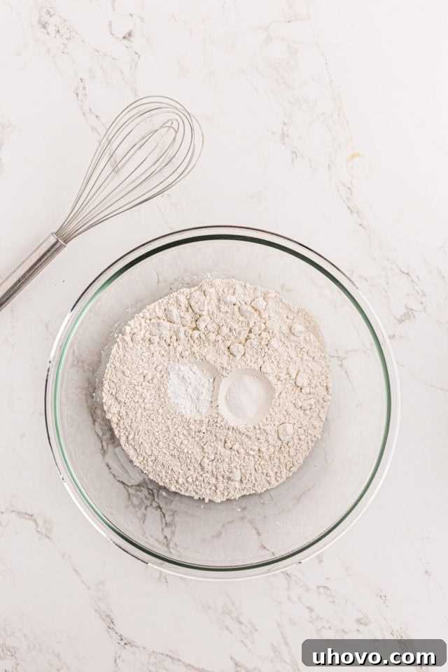 overhead view of flour, baking powder, and salt in a glass mixing bowl