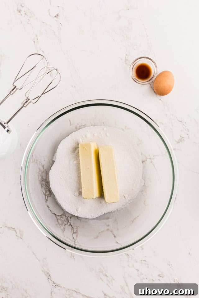 overhead view of butter and sugar in a glass mixing bowl