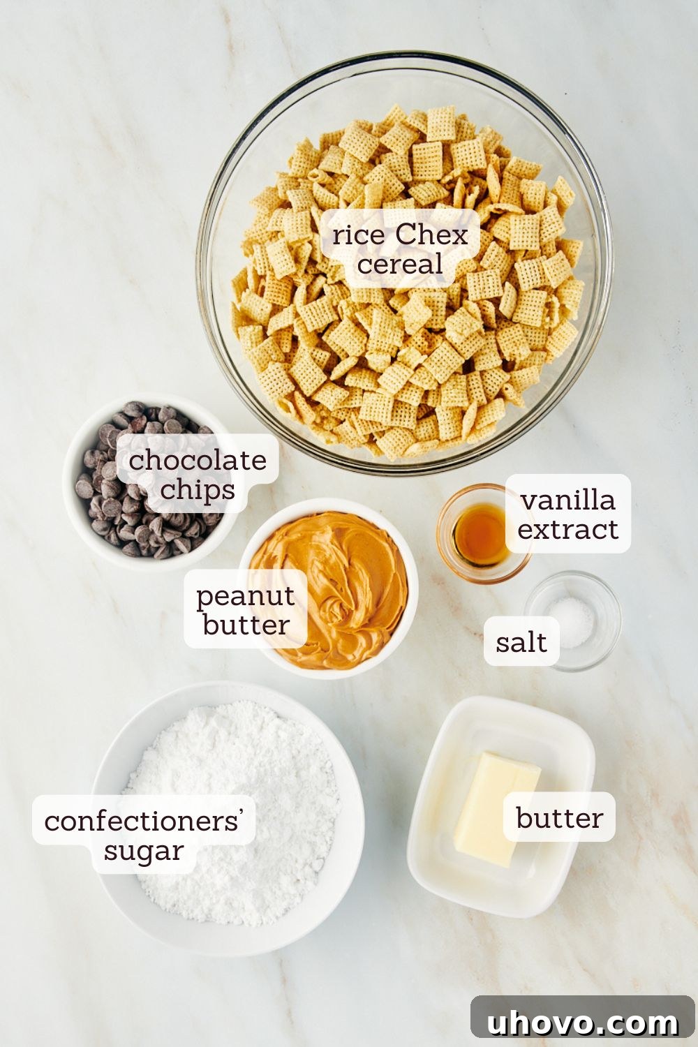 overhead view of labeled ingredients for muddy buddies including chocolate chips, peanut butter, butter, vanilla, salt, Chex cereal, and confectioners' sugar