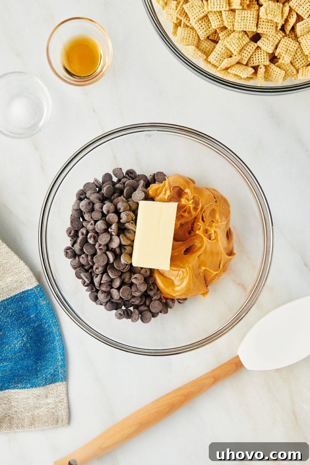 overhead view of chocolate chips, peanut butter, and butter in a glass mixing bowl, ready to be melted