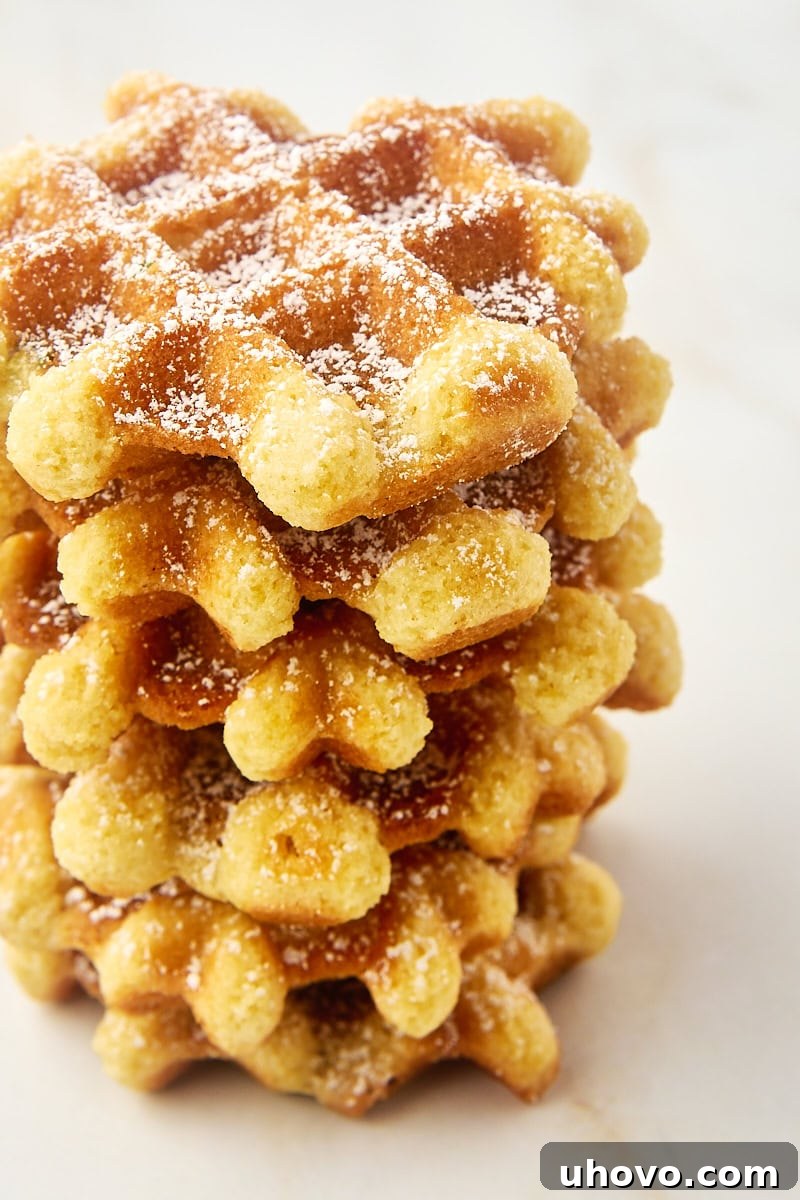 A beautifully arranged stack of golden-brown waffle cookies sitting on a elegant marble countertop, emphasizing their inviting texture and perfect browning.